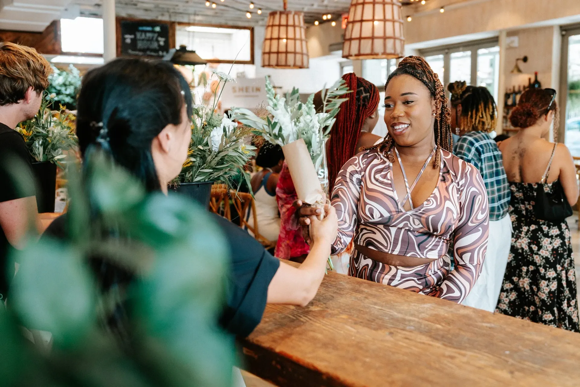 A woman is standing at a counter in a restaurant talking to another woman.