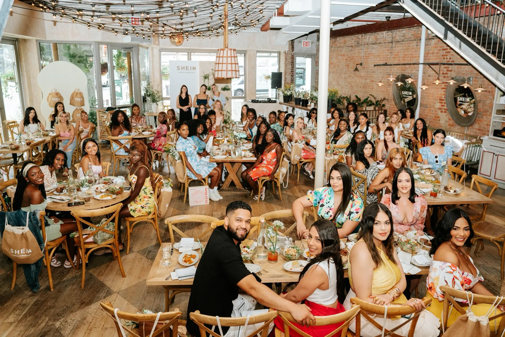 A large group of people are sitting at tables in a restaurant.