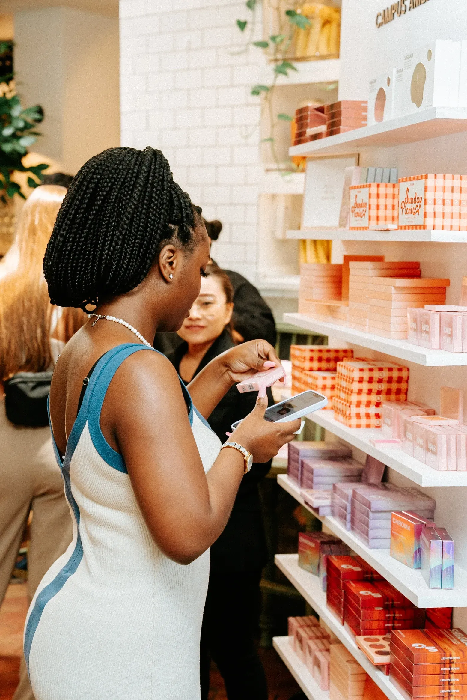 A woman is looking at a cell phone in a store.