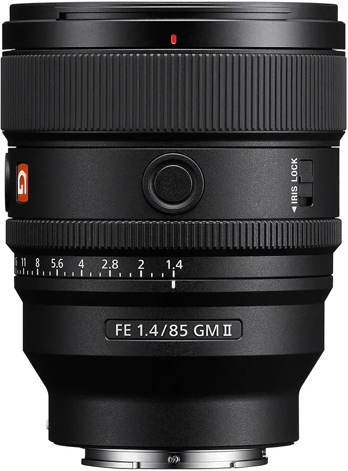 A close up of a black camera lens on a white background.