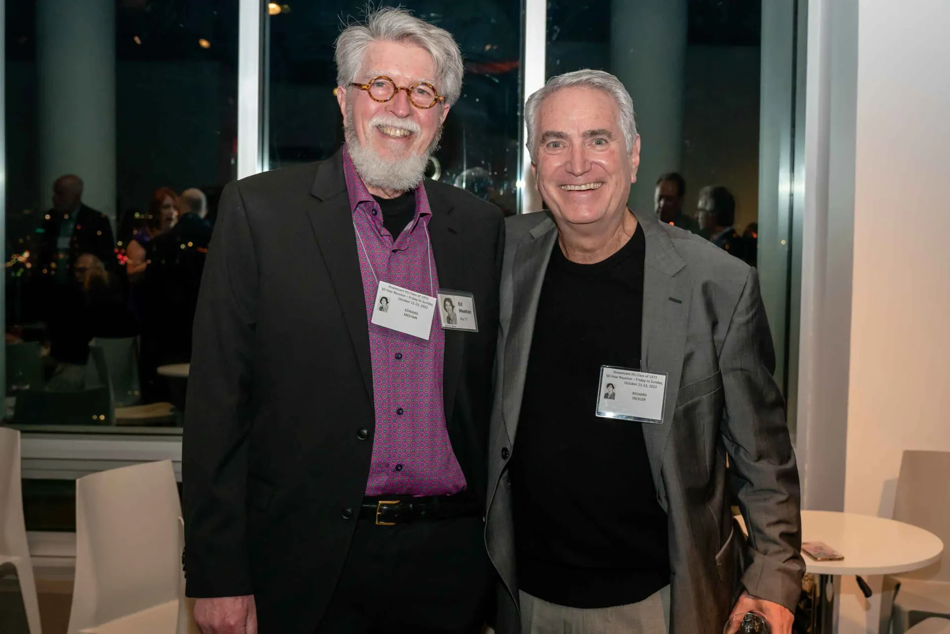 Two men are posing for a picture together in a room.