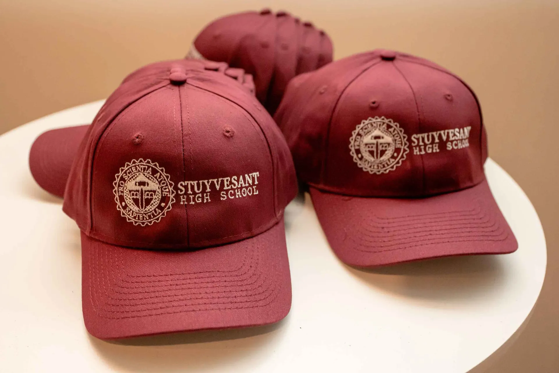 Two maroon hats with the word stuyvesant on them