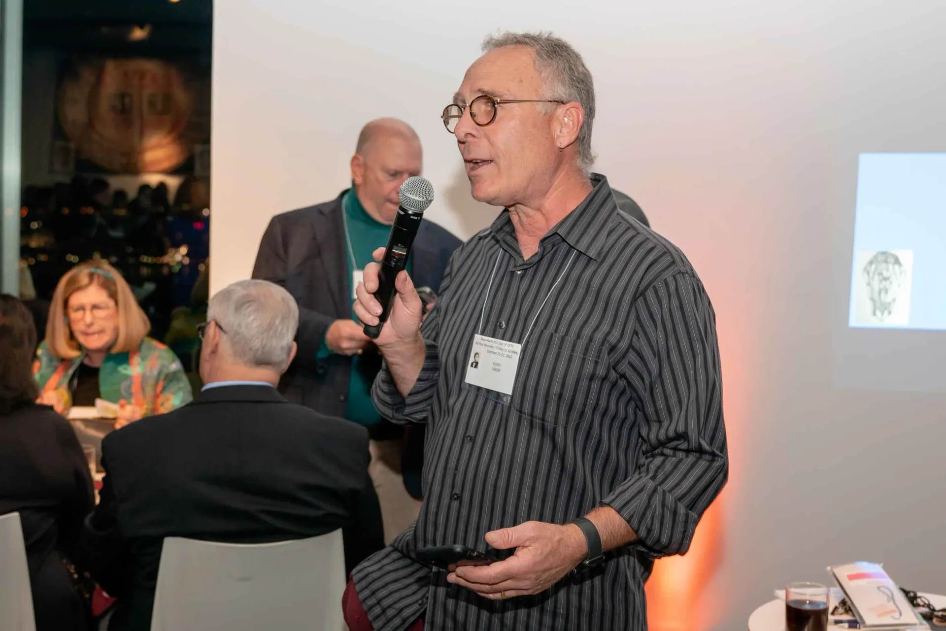 A man is holding a microphone in front of a group of people.