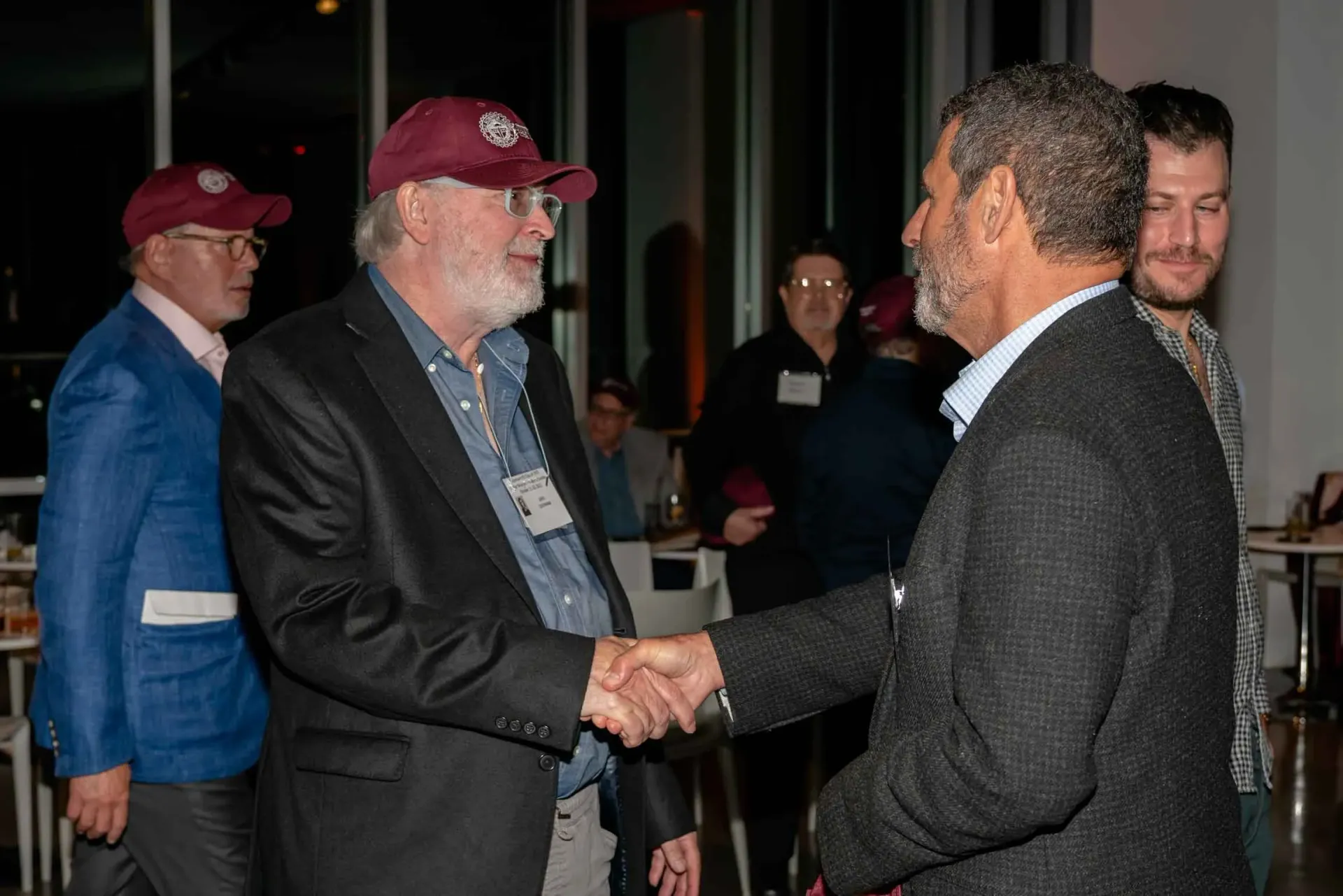 A group of men are shaking hands in a room.