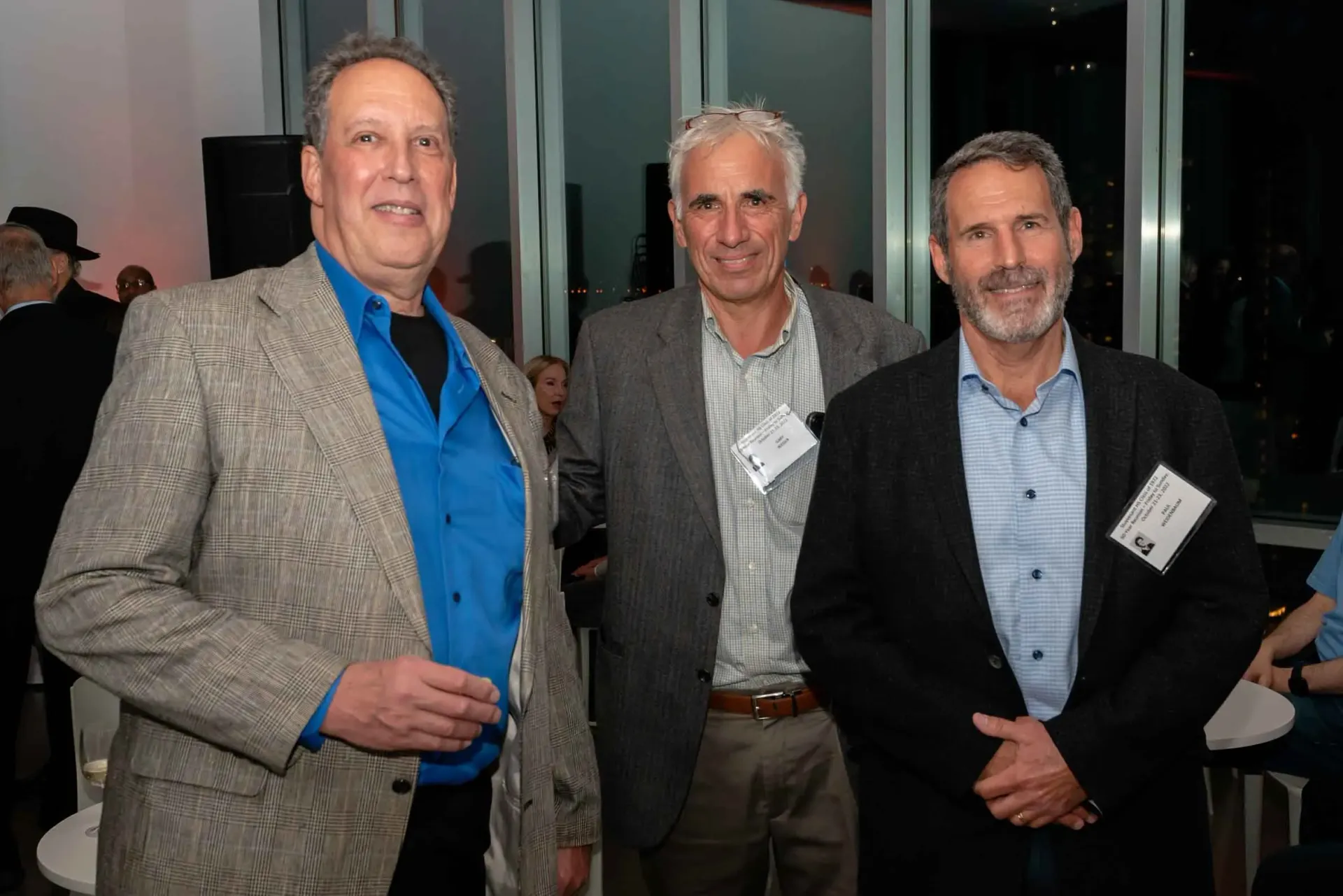 Three men are posing for a picture together at a party.