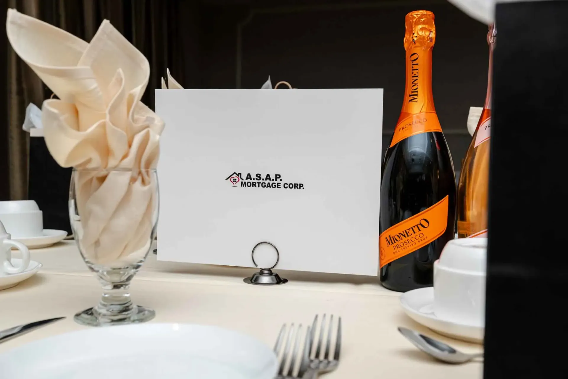 A bottle of wine is sitting on a table next to a napkin holder.