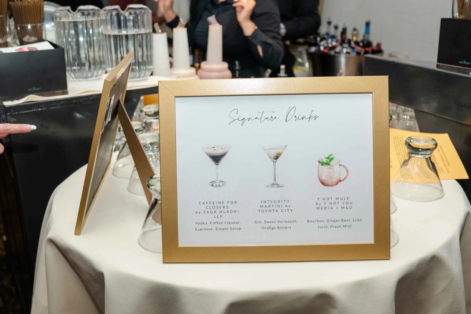 A table with a sign on it that says signature drinks