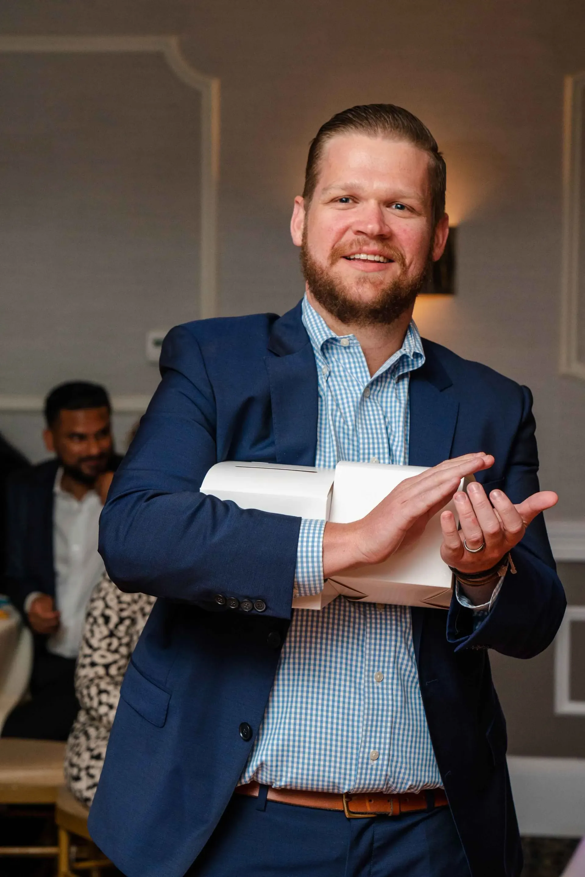 A man in a suit is holding a piece of paper in his hand.