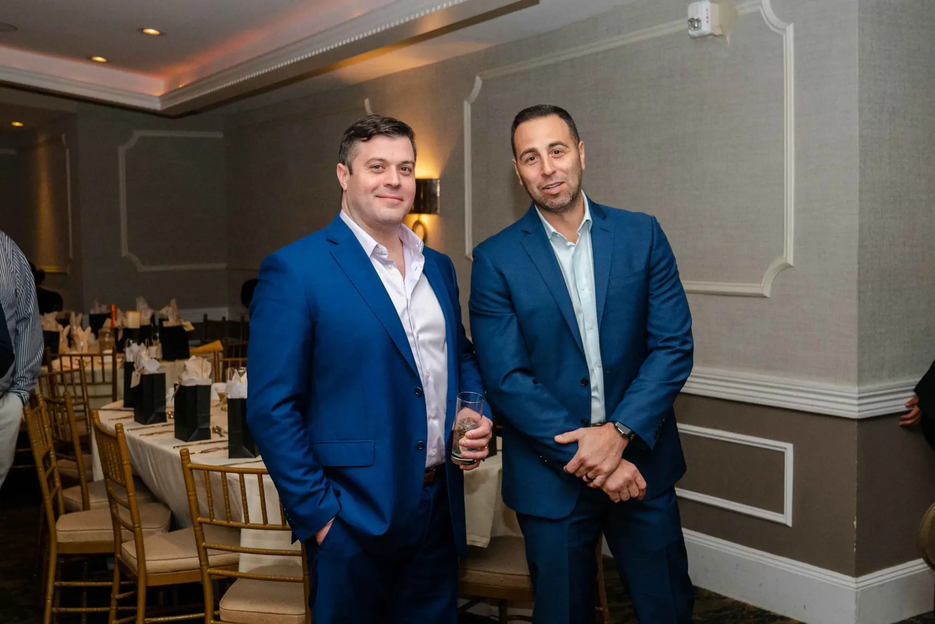 Two men in suits are standing next to each other in a room.