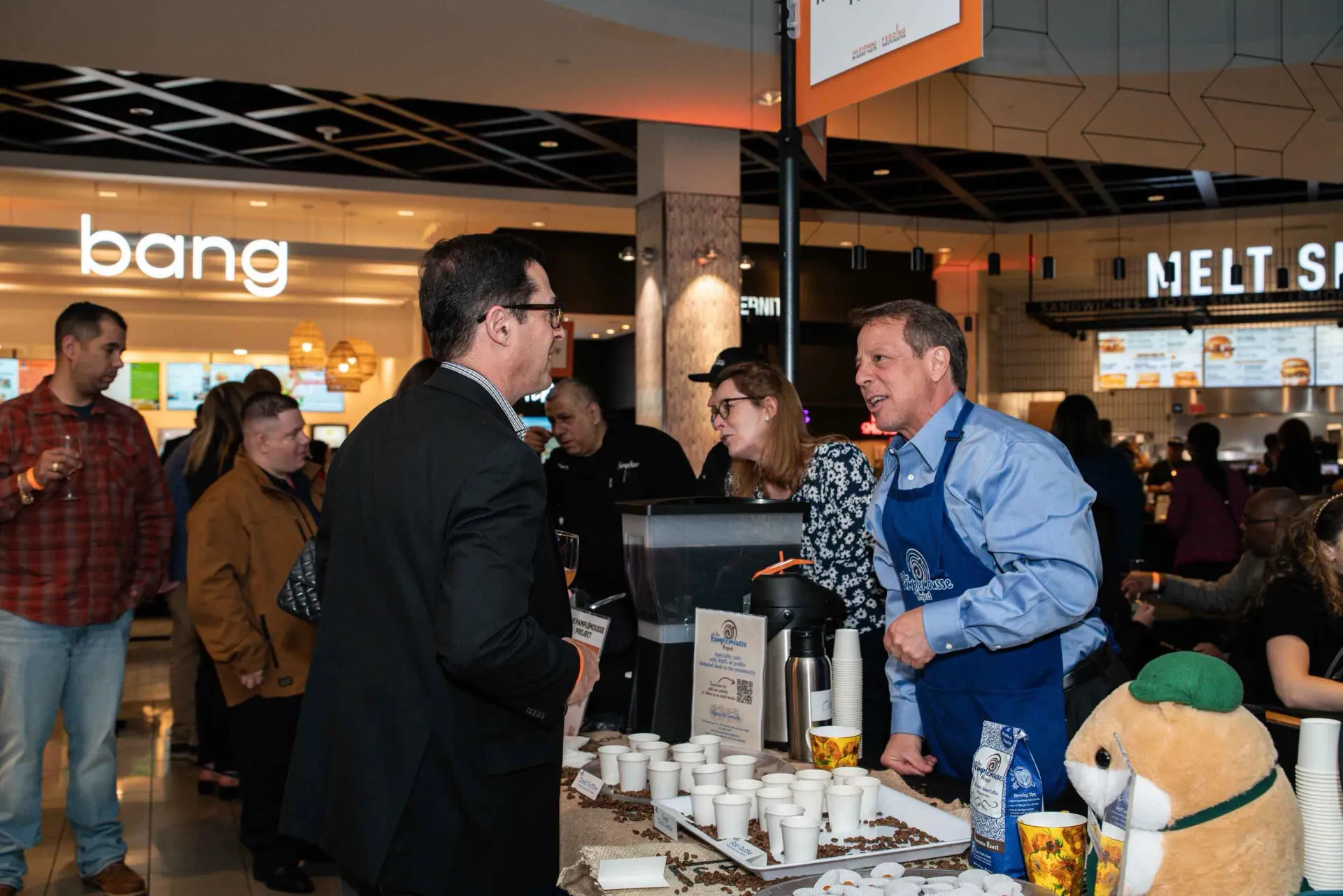 A group of people are standing around a table in a restaurant.