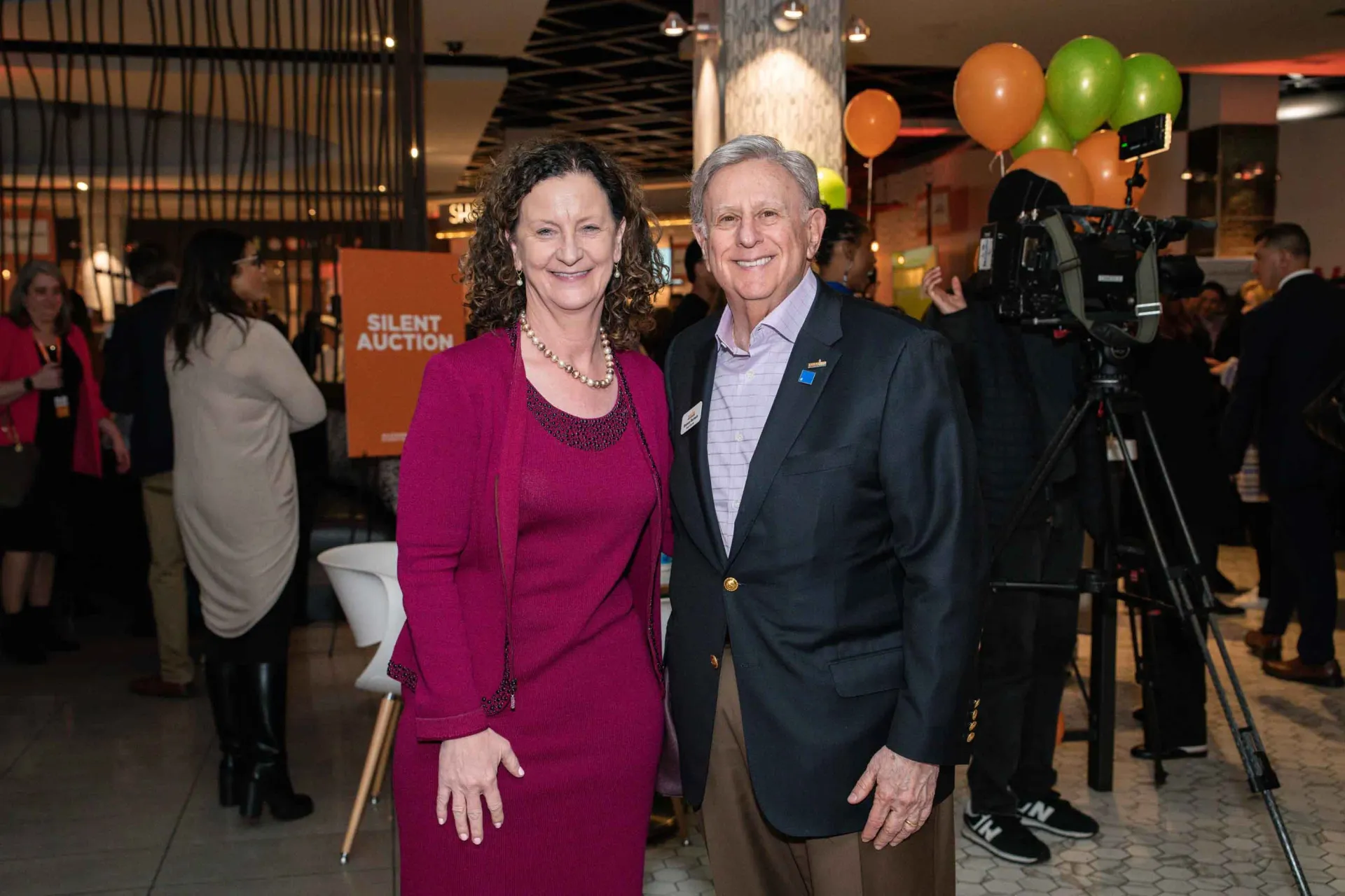 A man and a woman are posing for a picture at a party.
