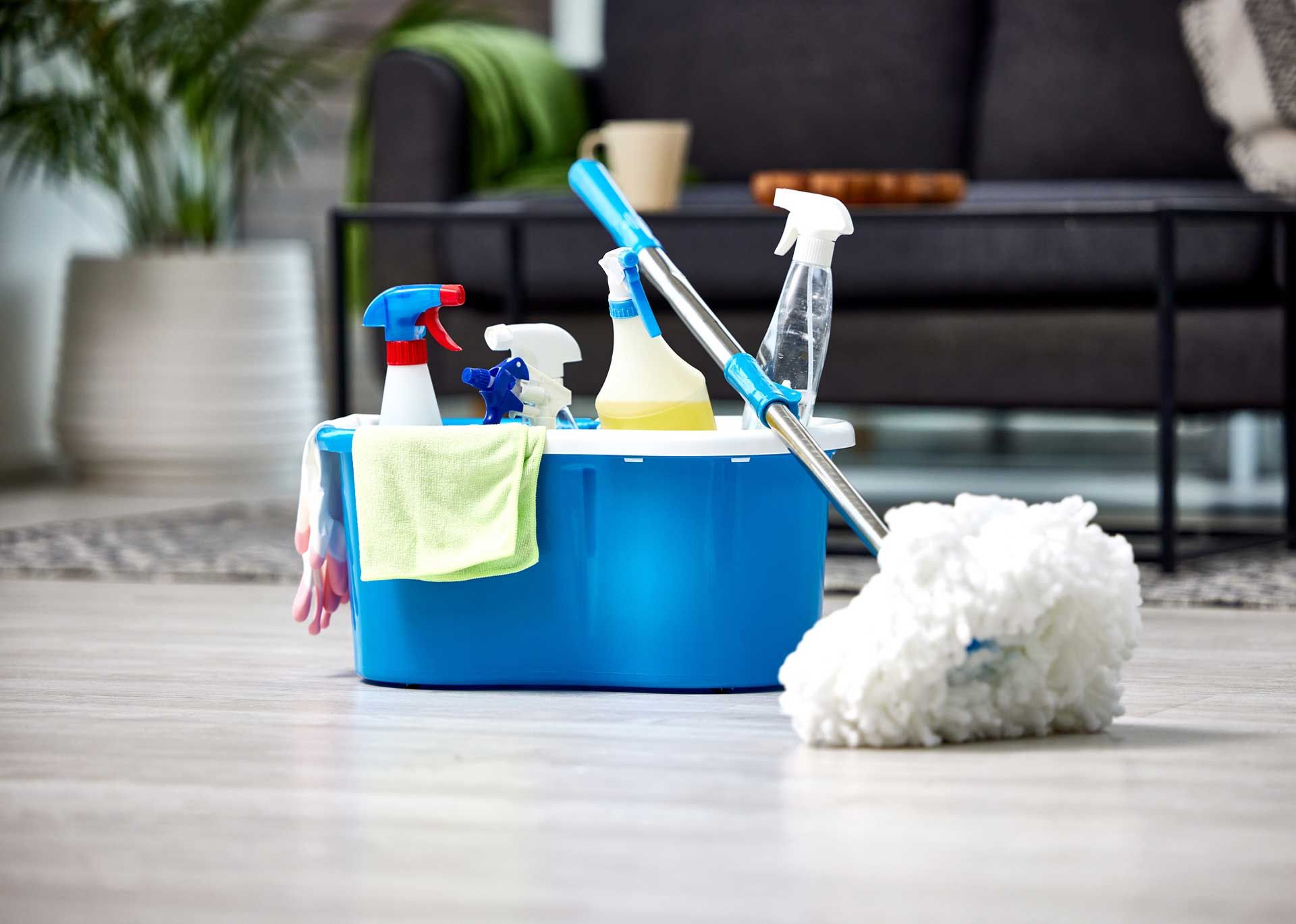 A mop is sitting on the floor next to a bucket of cleaning supplies.