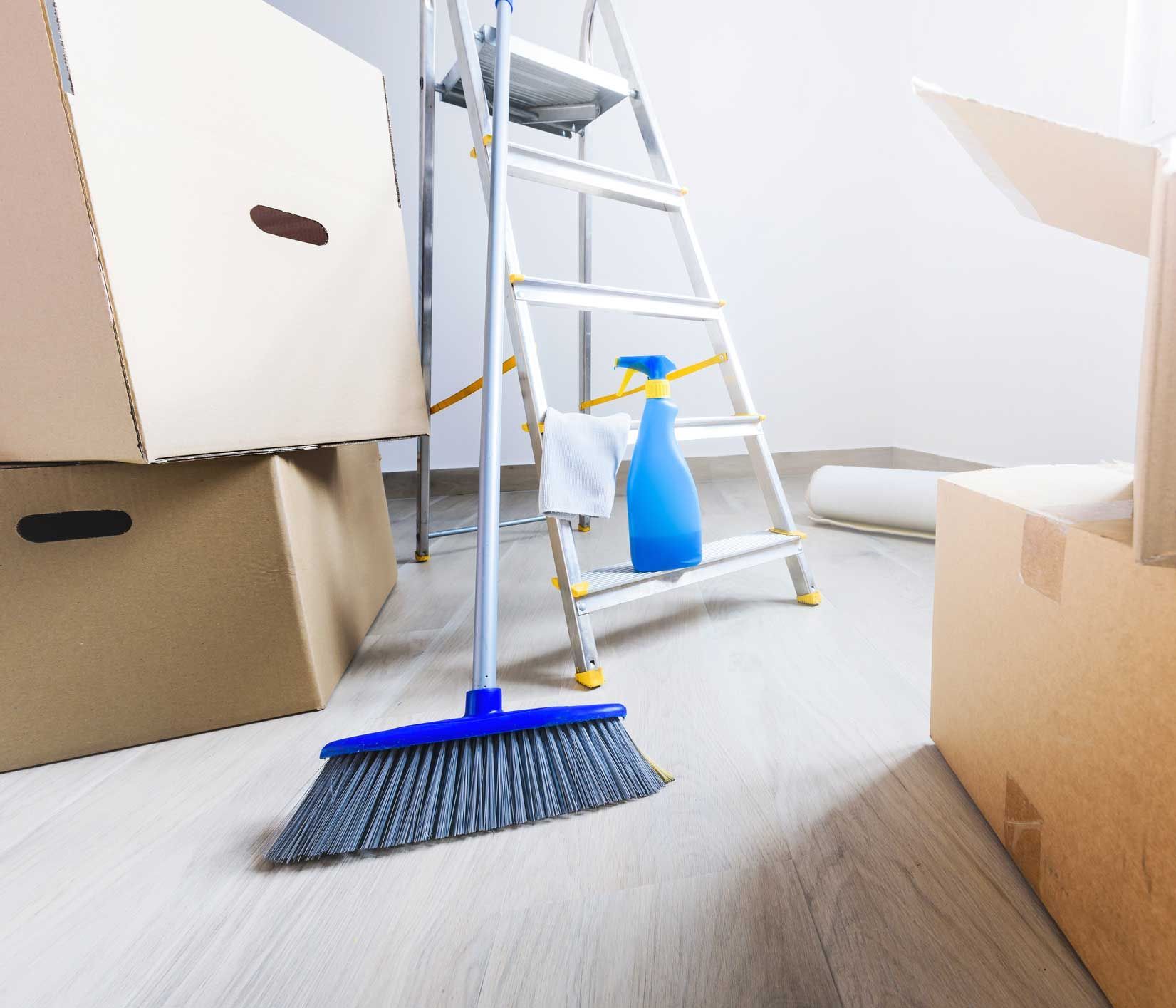 A room with boxes and a ladder and a broom