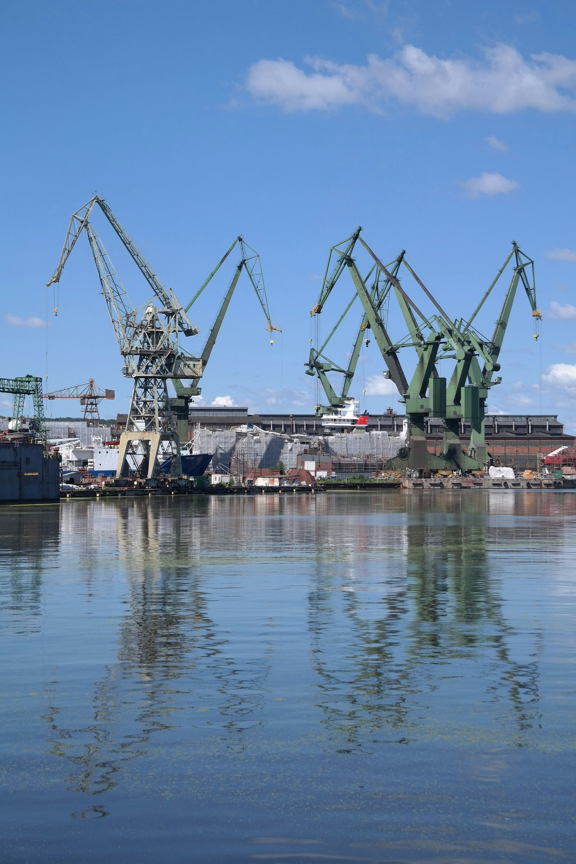 A large body of water with cranes in the background