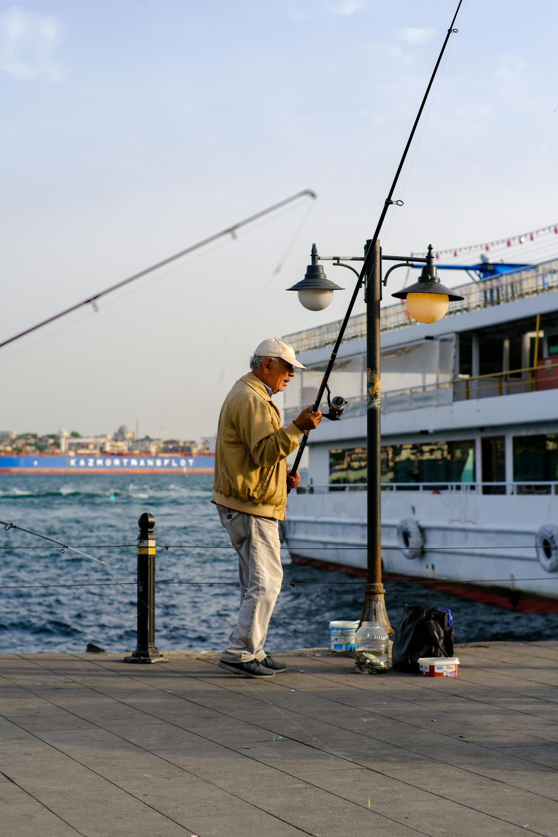A man is fishing in the water near a boat
