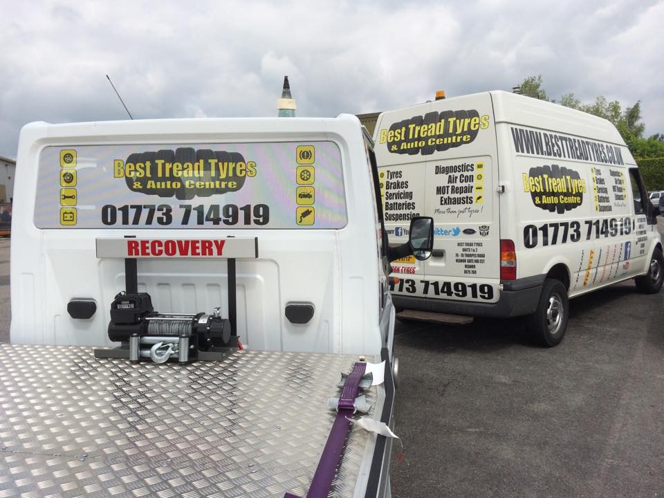 vehicle graphics on a white van and a recovery truck