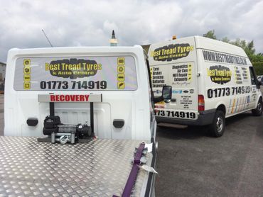 vehicle graphics on a white van and a recovery truck