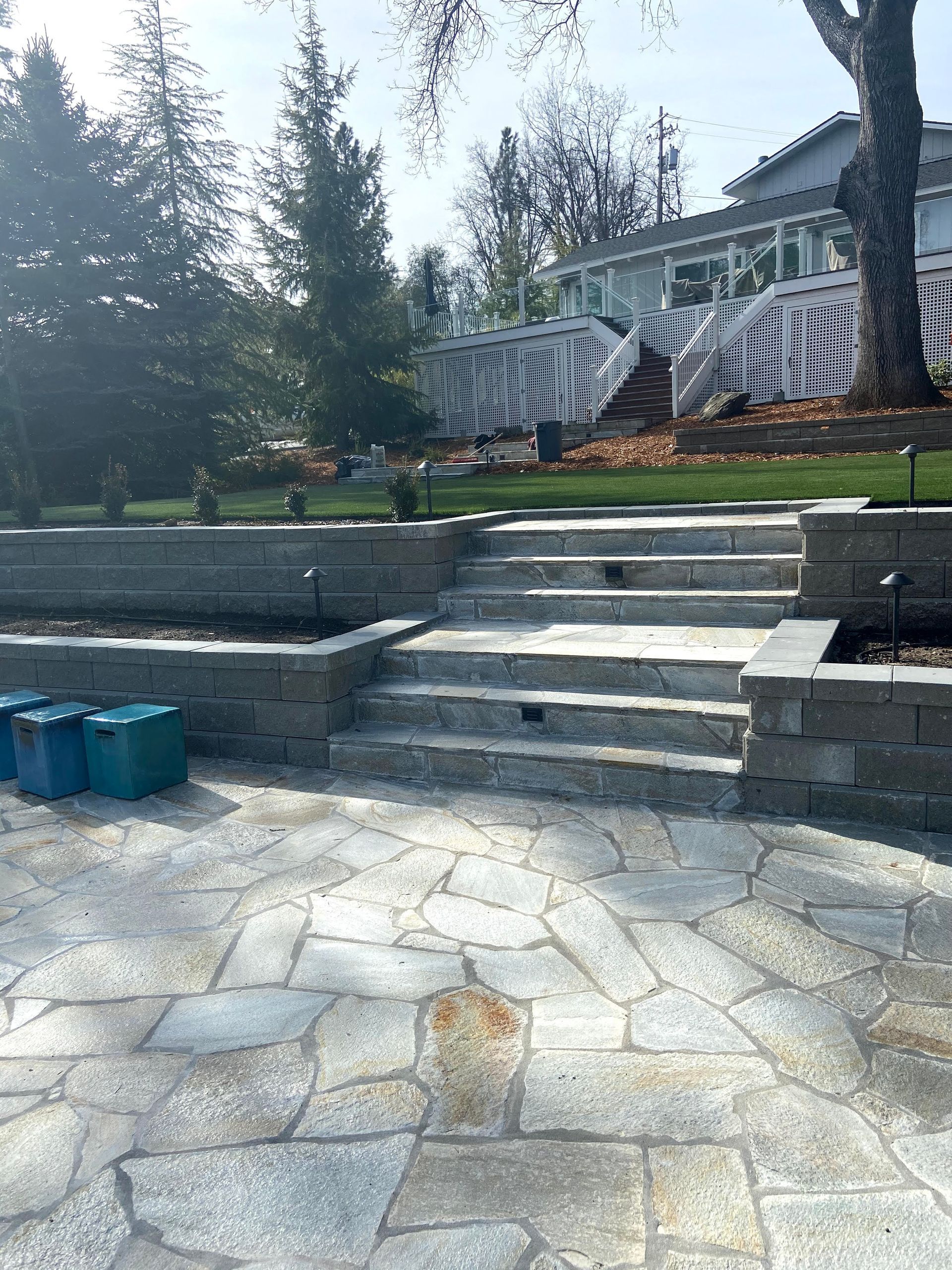 A stone patio with stairs leading up to a house