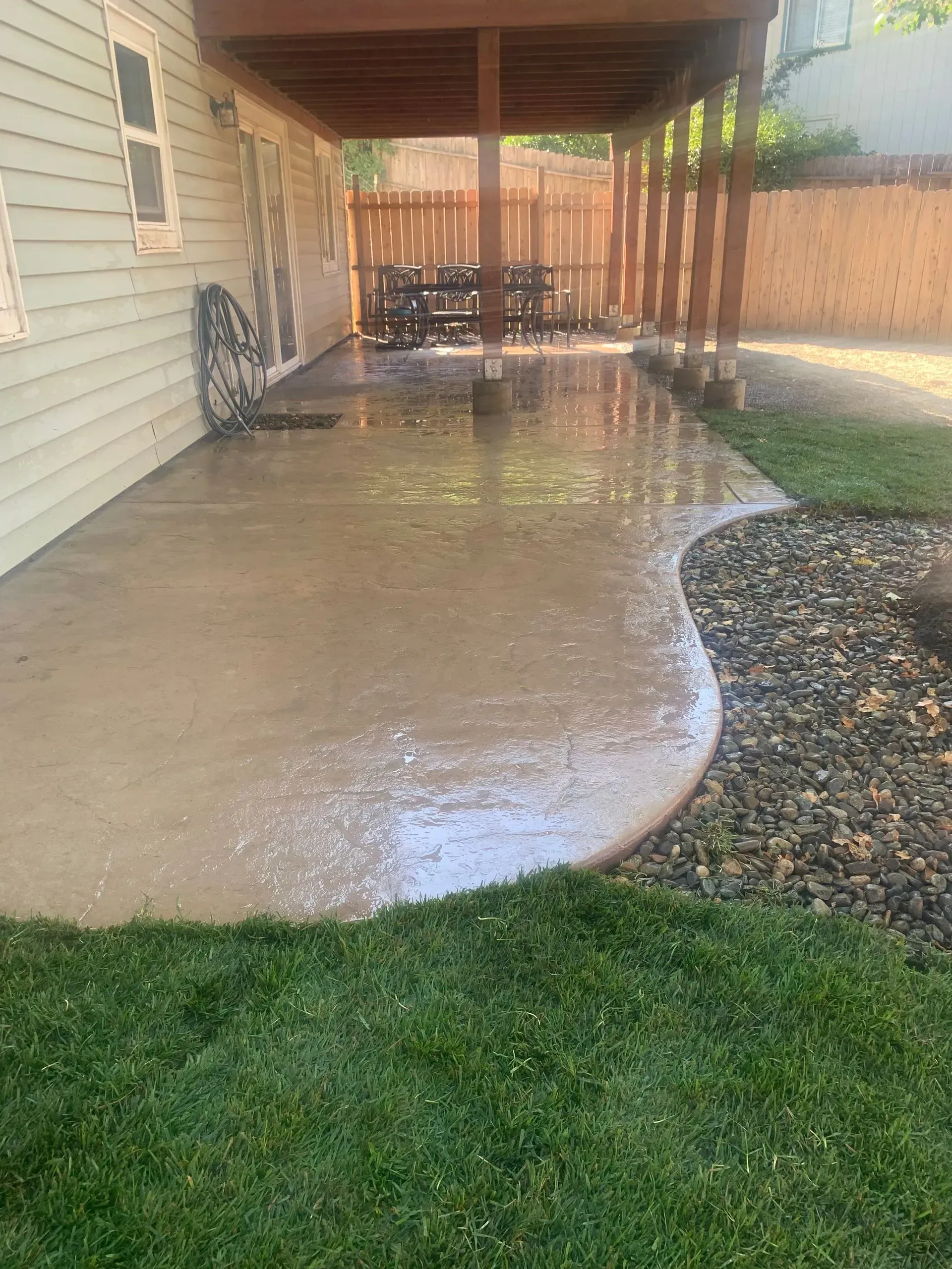 A patio with a covered area and a table and chairs underneath it.