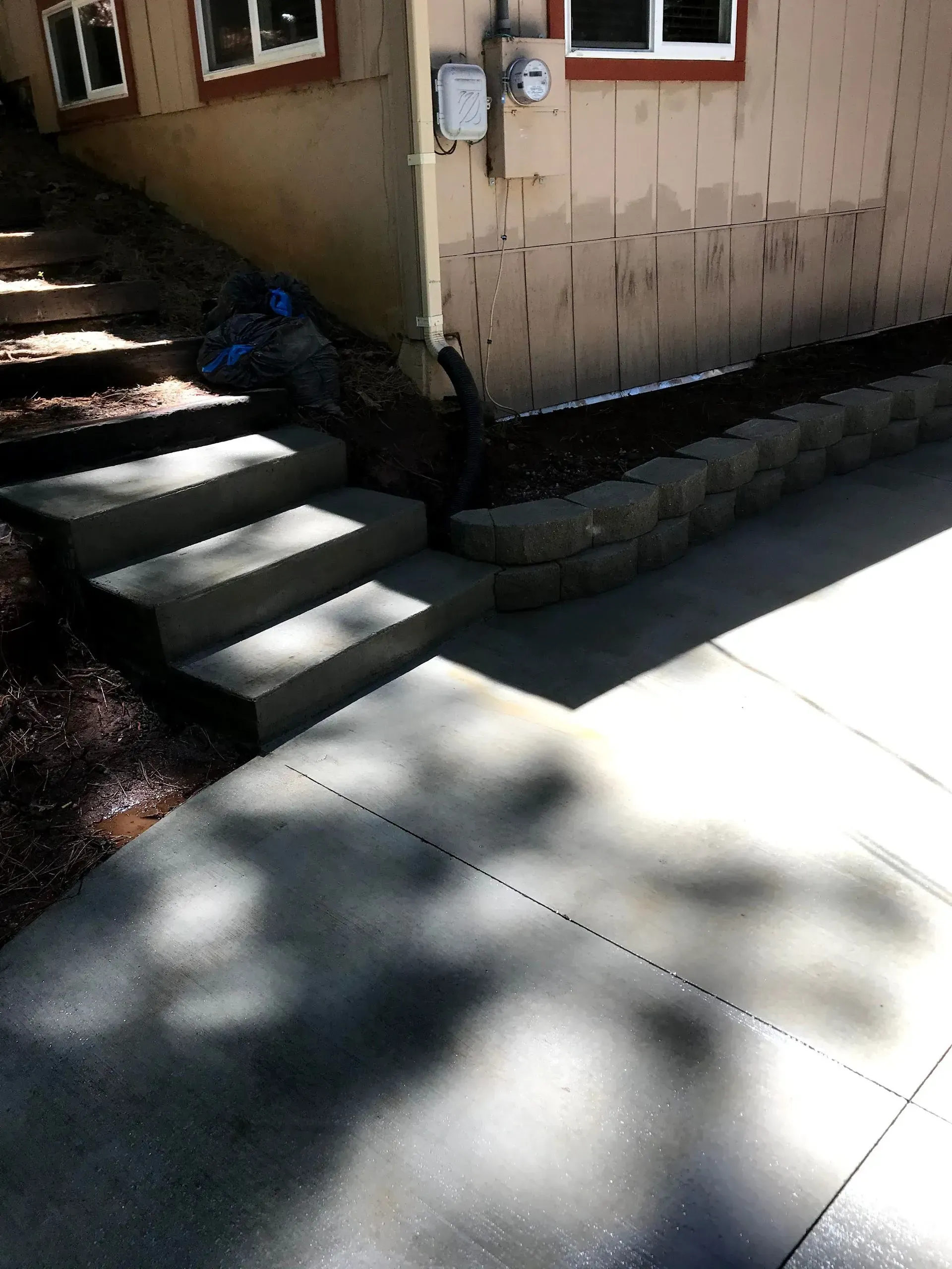 A concrete walkway with stairs leading up to a house