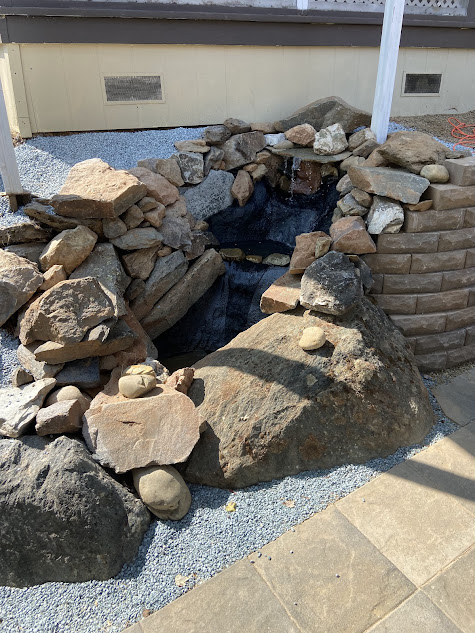 There is a small waterfall in the middle of a pile of rocks.