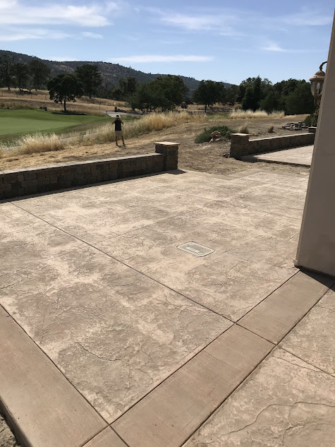 A concrete patio with a view of a golf course.