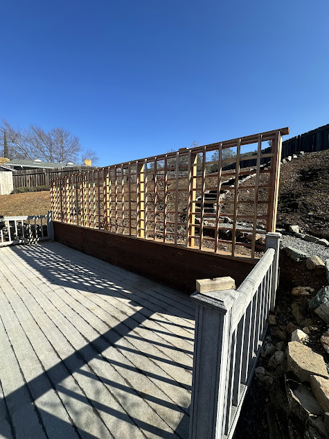 A wooden deck with a wooden fence surrounding it.