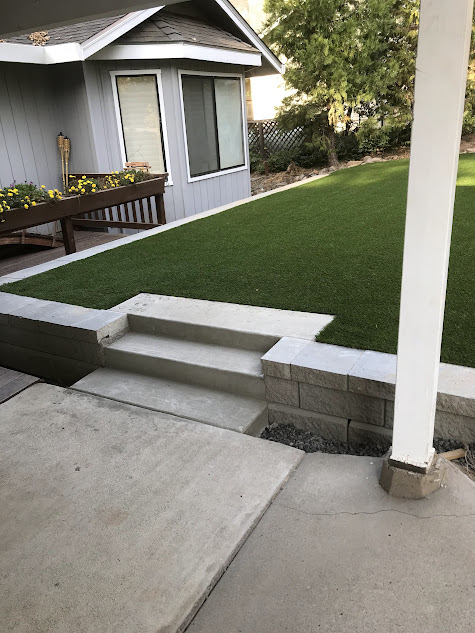 A house with a lawn and stairs in front of it.