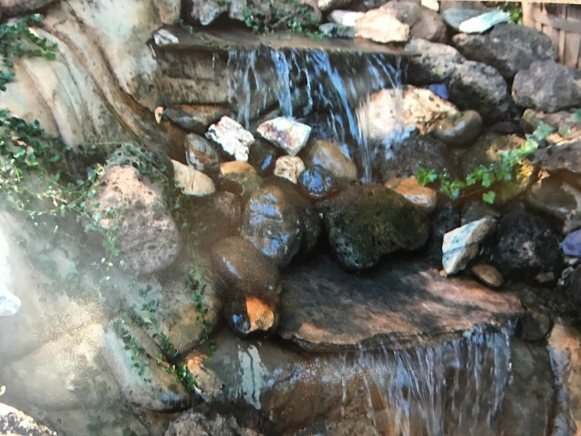 A waterfall is surrounded by rocks and moss.