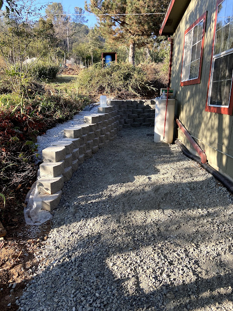 A brick wall is being built in front of a house.