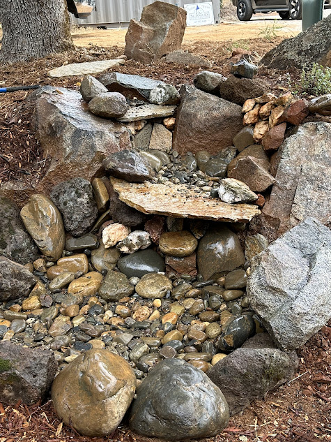 A pile of rocks sitting on top of a dirt field.