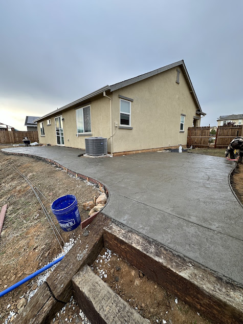 A concrete walkway is being built in front of a house.