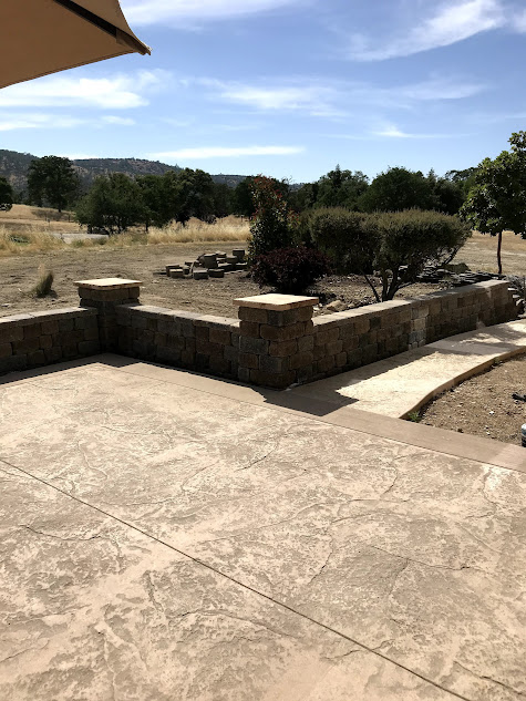 A patio with a view of a field and trees.