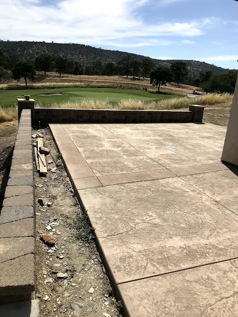 A patio with a view of a golf course in the background.