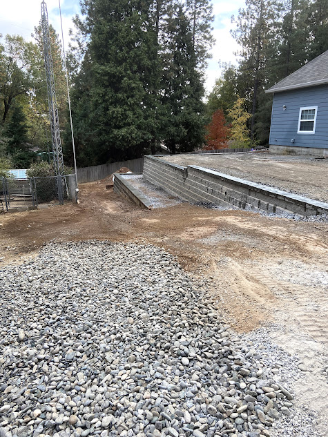 A large pile of gravel is sitting in front of a house.