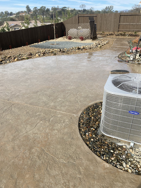 A large air conditioner is sitting on top of a concrete patio.