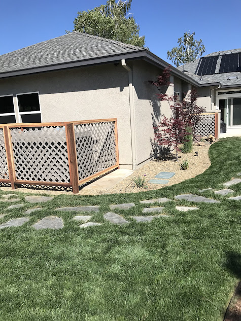 A house with a fence and a walkway in front of it.
