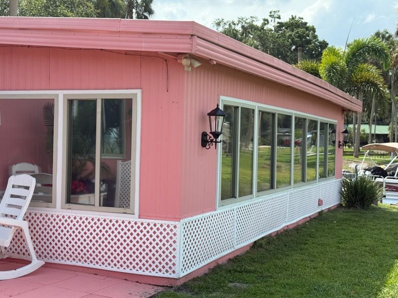 A pink house with a white chair in front of it