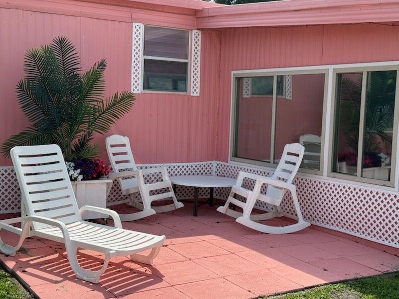 A pink house with white chairs and a table