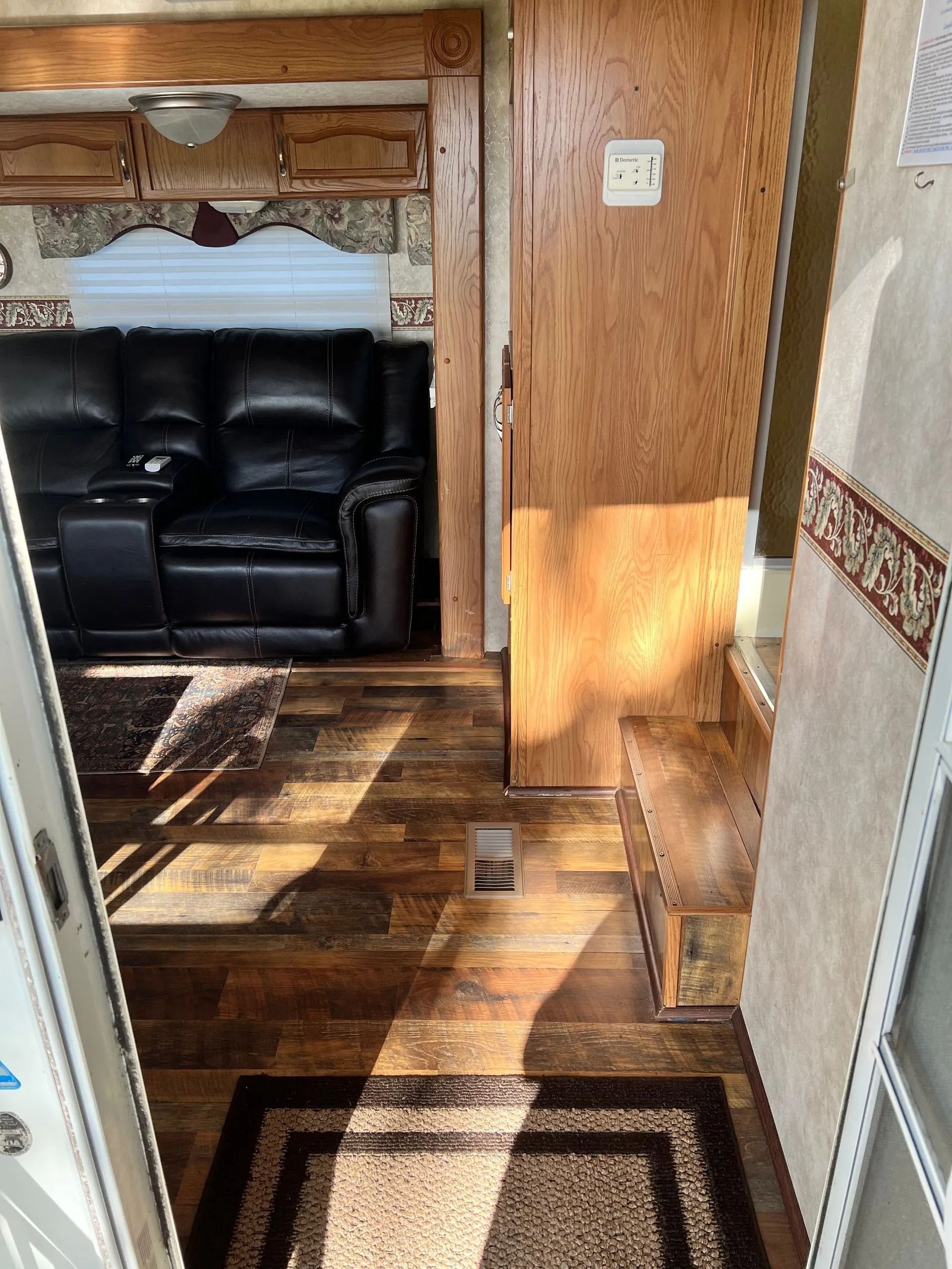 A living room with a couch , rug and stairs.