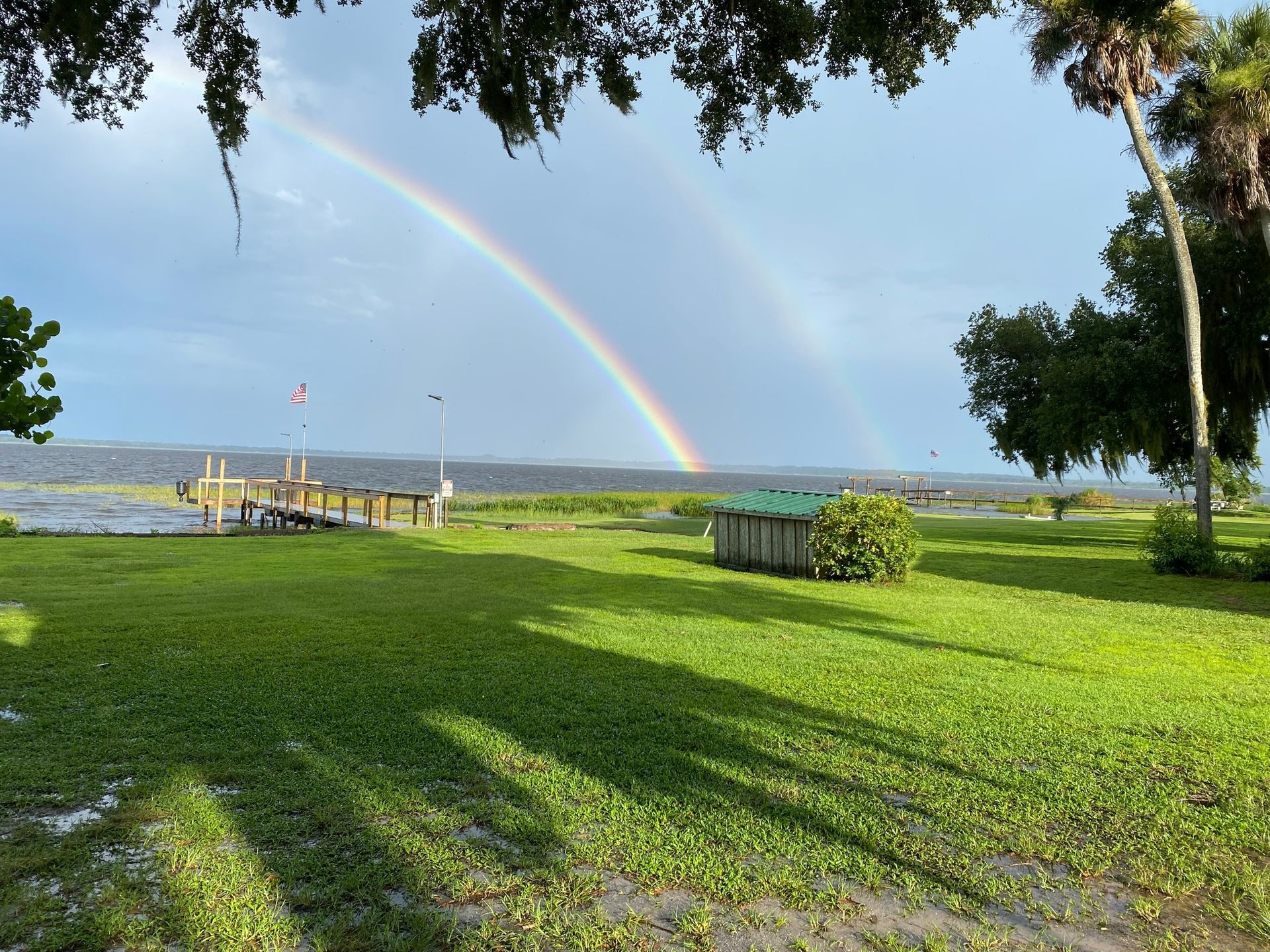 There is a rainbow in the sky over the water.