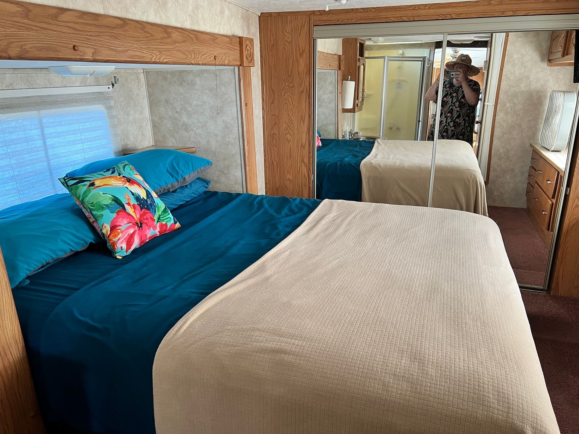 A bedroom in a camper with a bed and a mirror