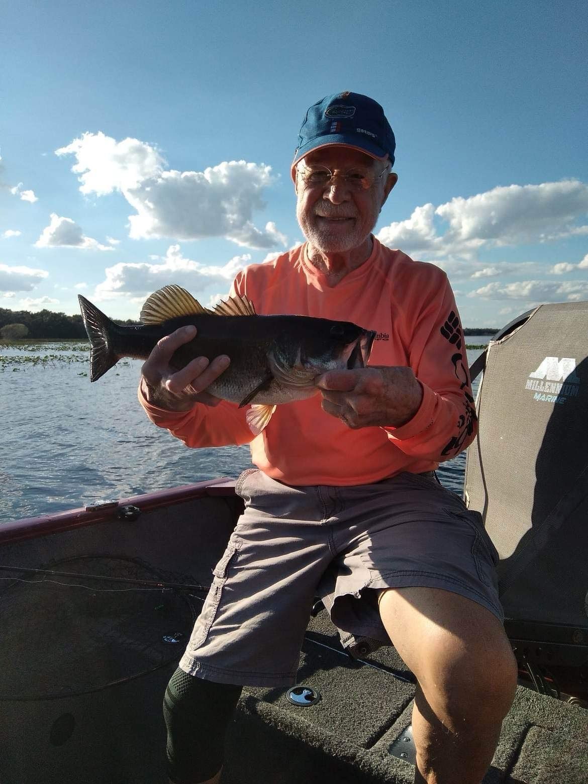A man is sitting in a boat holding a fish.