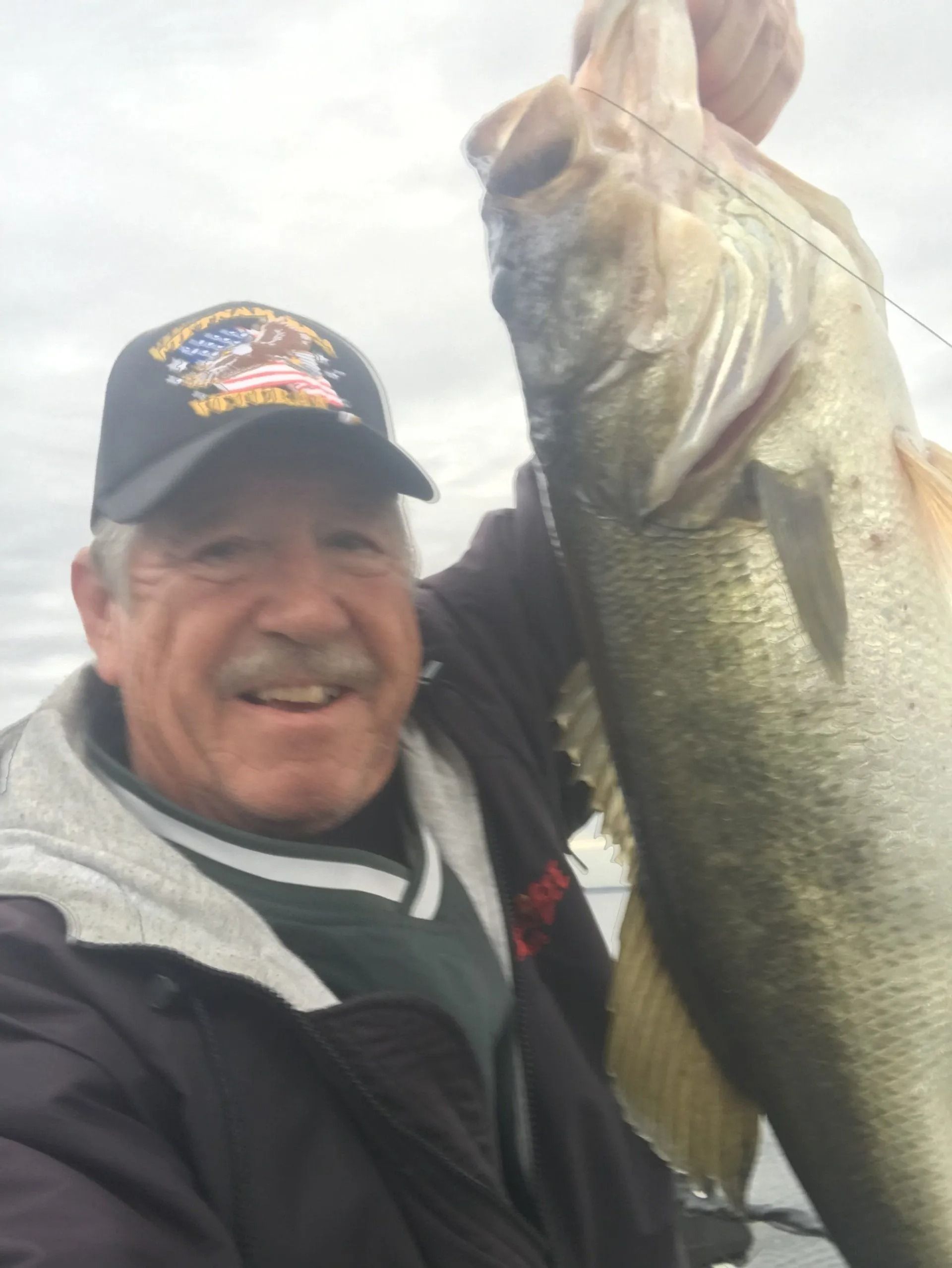 A man is holding a large fish in his hands