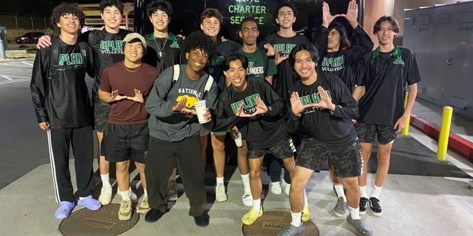 A group of young men are posing for a picture in a parking lot.