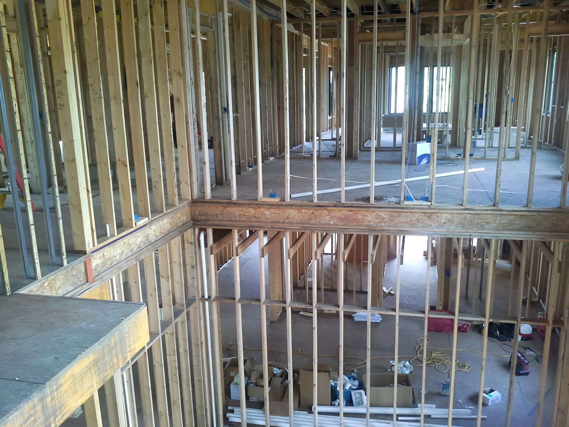 Interior view of a building under construction, showing wooden framing and multiple levels.
