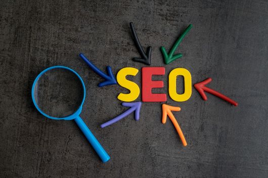 The word seo is surrounded by colorful arrows and a magnifying glass.