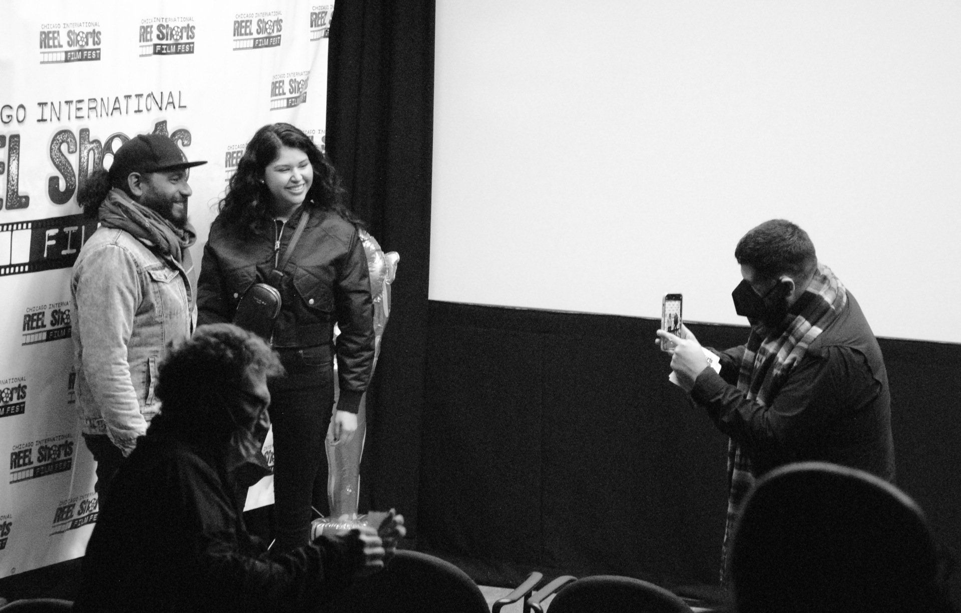 A man is taking a picture of a group of people in a theater.