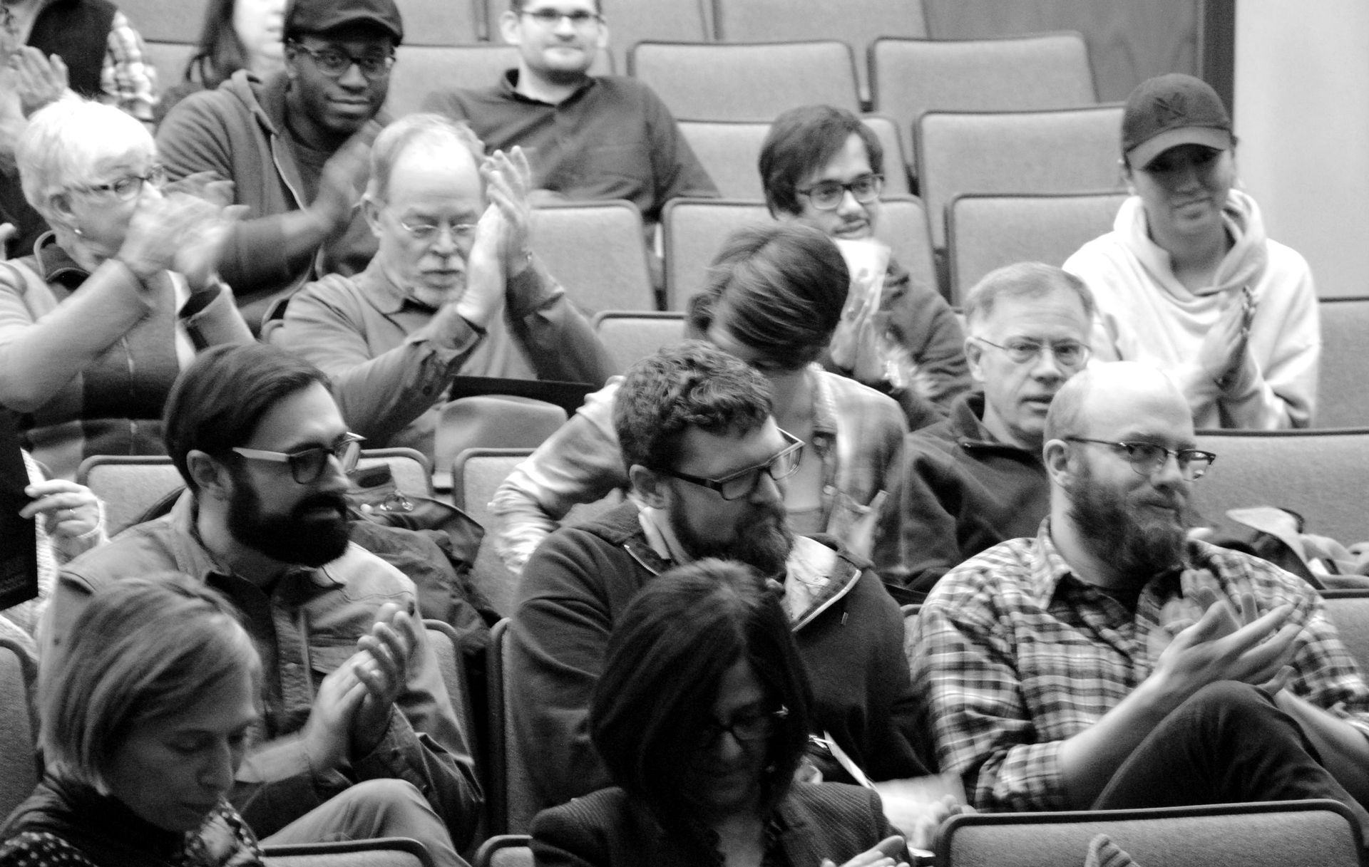 A black and white photo of a group of people sitting in an auditorium.