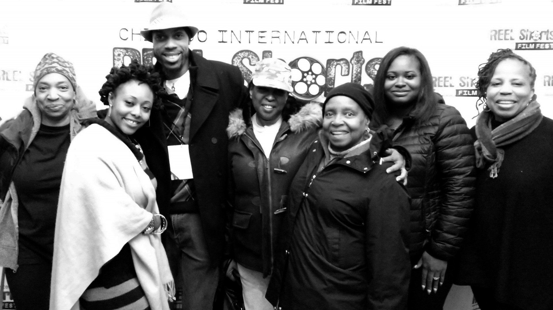 Group poses at Chicago Film Festival. People of color, smiles. Outdoor setting, black and white photo.